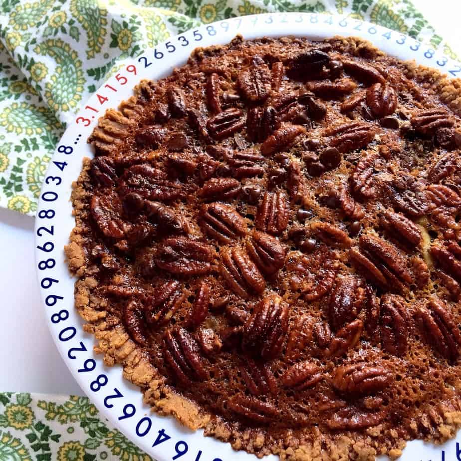 Closeup of the chocolate maple pecan pie looking extra inviting and served on a big white plate.