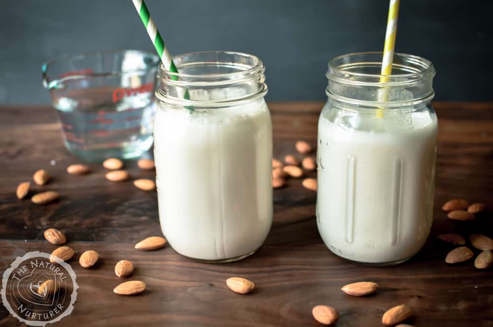 Ridiculously Easy Homemade Almond Milk served in two cute jars with straws in them.