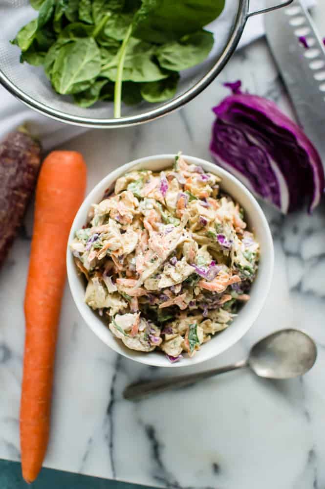 Overhead on the healthy Veggie-Loaded Spring Chicken Salad with carrot and cabbage on the sides