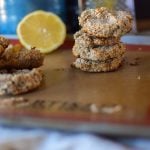 A stack of healthy and delicious Paleo Lemon Breakfast Cookies with a lemon wedge blurred in the background