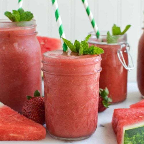 Closeup of the Watermelon Mint Slushies served in cute little jars with striped straws