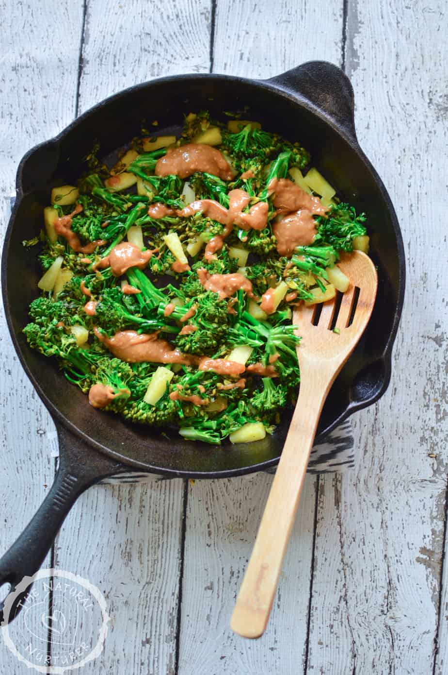 Pineapple Broccoli Stir Fry with Thai Peanut Sauce in a skillet served on a big white table