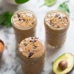Healthy Peanut Butter Chocolate Smoothie made with greens and served in three glass jars on a marble table