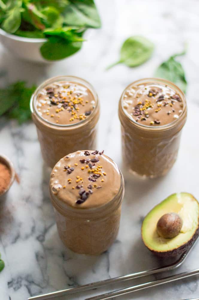 Healthy Peanut Butter Chocolate Smoothie made with greens and served in three glass jars on a marble table