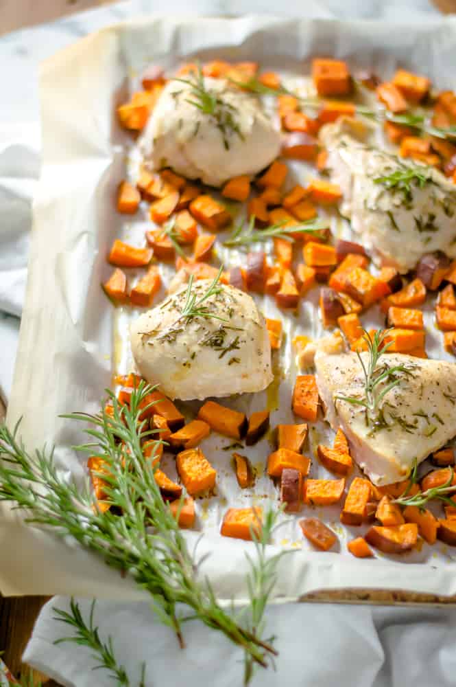 One-Sheet Rosemary Baked Chicken & Sweet Potatoes served hot with rosemary sprigs on the side