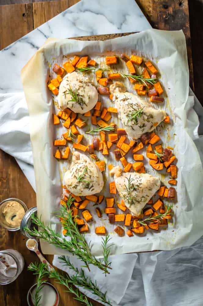 Delicious homemade One-Sheet Rosemary Baked Chicken & Sweet Potatoes on a tray.