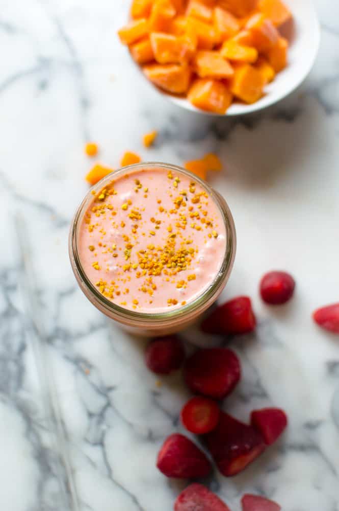Overhead on the healthy and delicious Sunrise Butternut Squash Smoothie with frozen strawberries around the jar