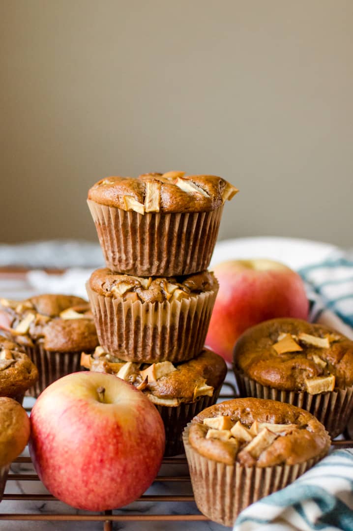 Healthy Paleo Apple Cinnamon Muffins served on top of each other with a couple of fresh apples around