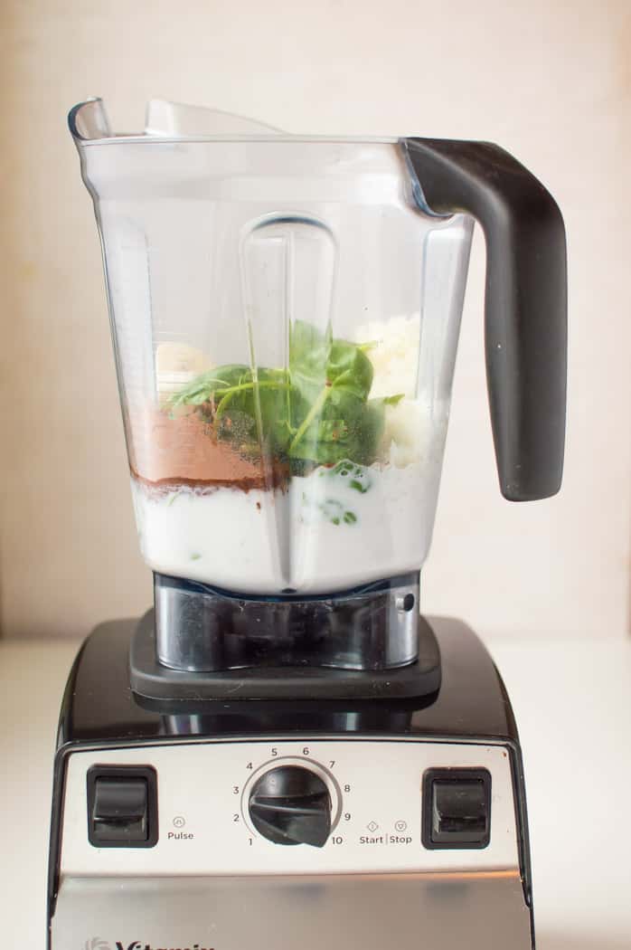 A big blender with lots of ingredient inside, ready to blend them all with a touch of a button