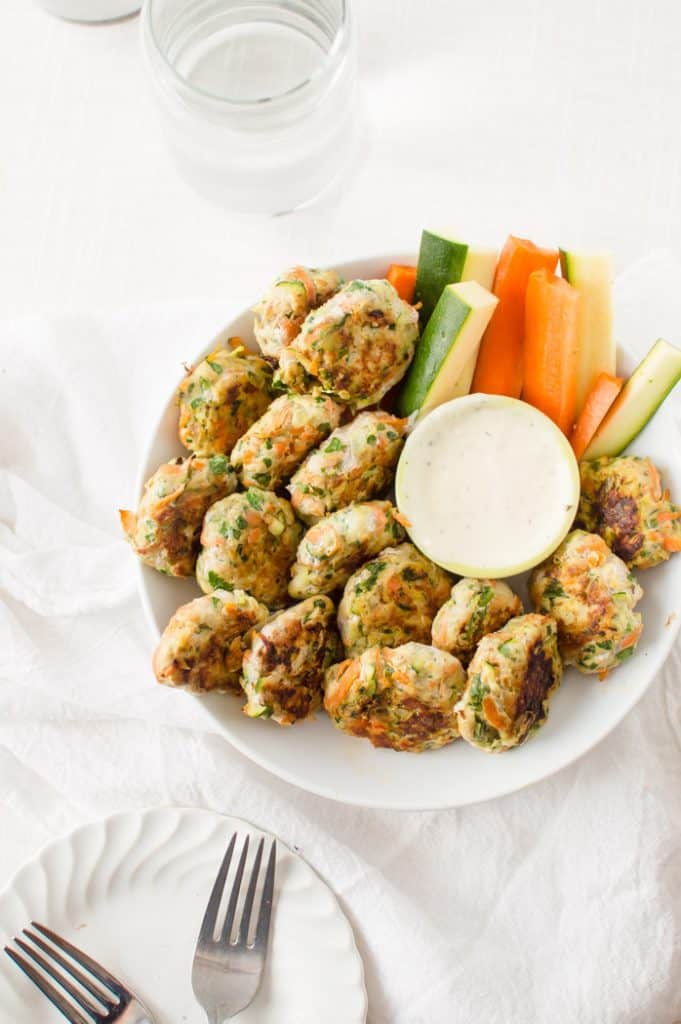 An overhead on the healthy and delicious Veggie-Loaded Chicken Bites with veggies on the side and mouthwatering sauce on the plate.