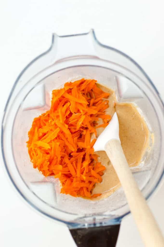 muffin batter in blender with grated carrots on top