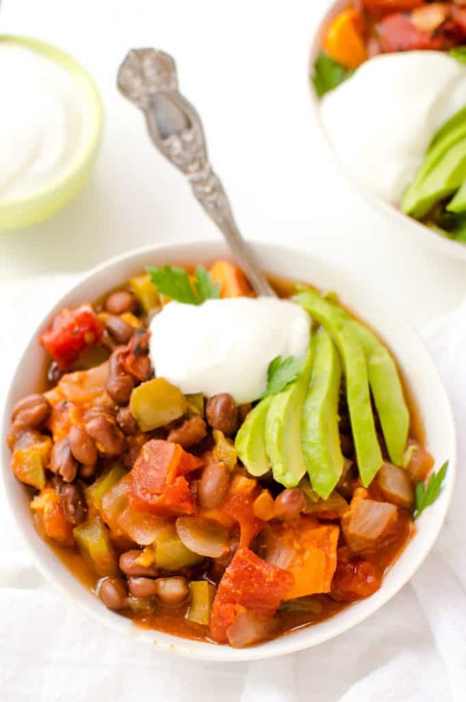   Slow Cooker Black Bean & Sweet Potato Chili is an easy, healthy and delicious dinner!  This slow cooker soup is full of warm cozy flavors and family-friendly. Gluten free + vegan.