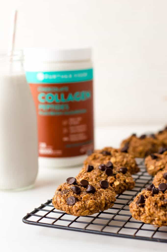 cookies on a cooling rack with a glass of milk next to it