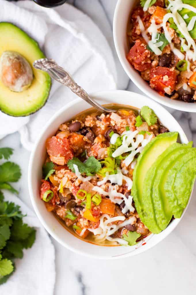 bowl of chili with avocado and cheese on top