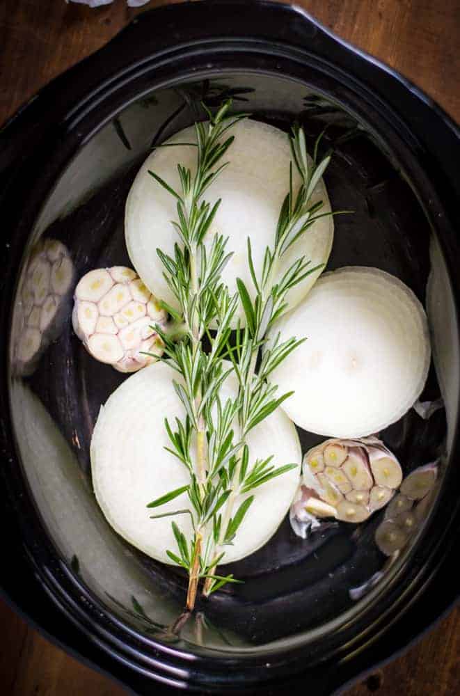 slow cooker with onions, garlic and herbs