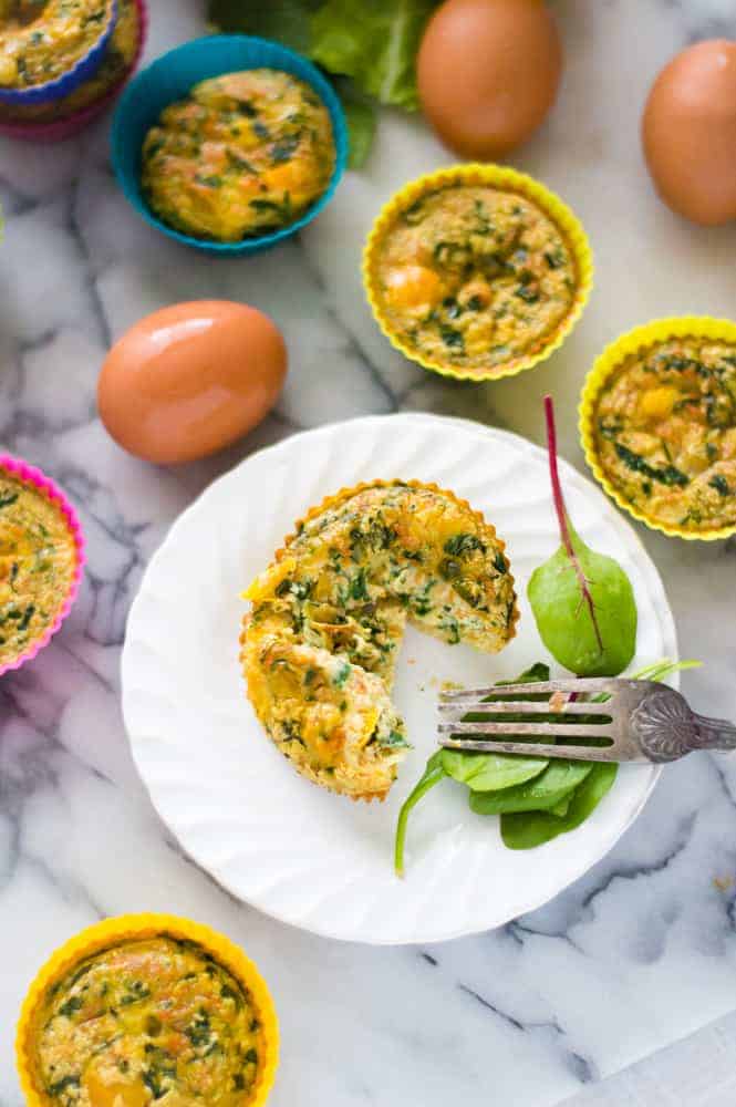 veggie-loaded egg cup on a plate, cup open and ready to eat.