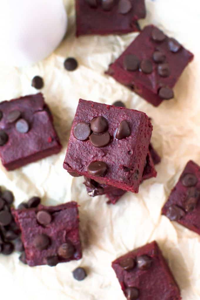 Sliced fudgy beet gluten free brownies stacked on parchment paper