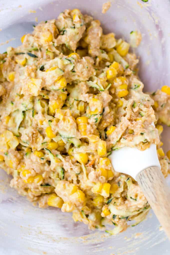The batter for zucchini and corn fritters all mixed together in a bowl, before it has been cooked. 