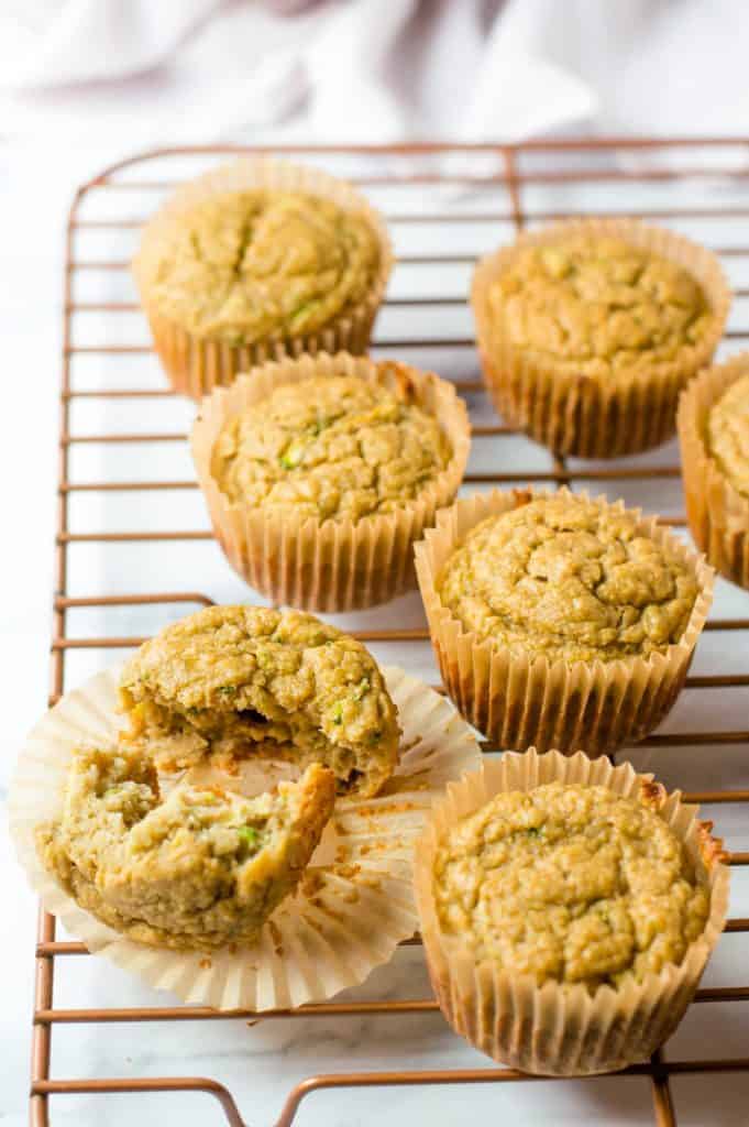 Healthy Zucchini Lemon Muffins on cooling rack, with one muffin cut open.
