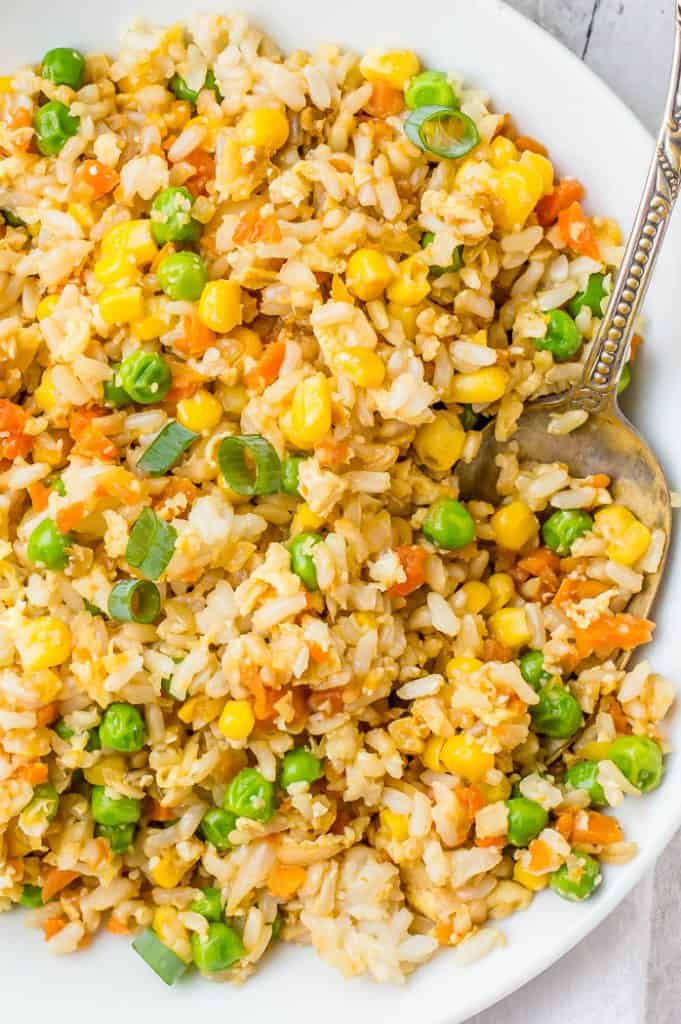 Veggie fried rice in a bowl with a metal spoon. 