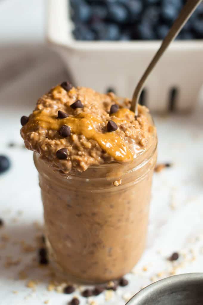 Serving Sweet Potato Chocolate Peanut Butter Overnight Oats in a jar with chocolate chips around