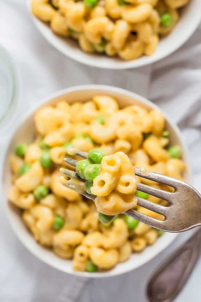 A forkful of veggie-loaded mac and cheese over a bowl of it.