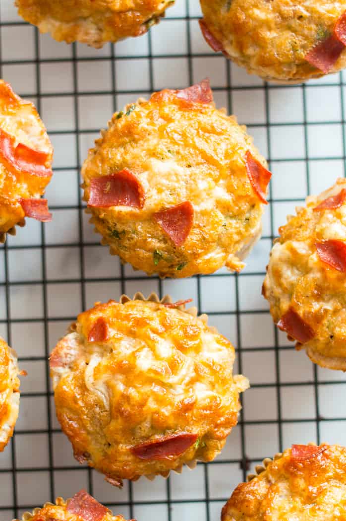 Veggie-loaded pizza muffins on a cooling rack. 