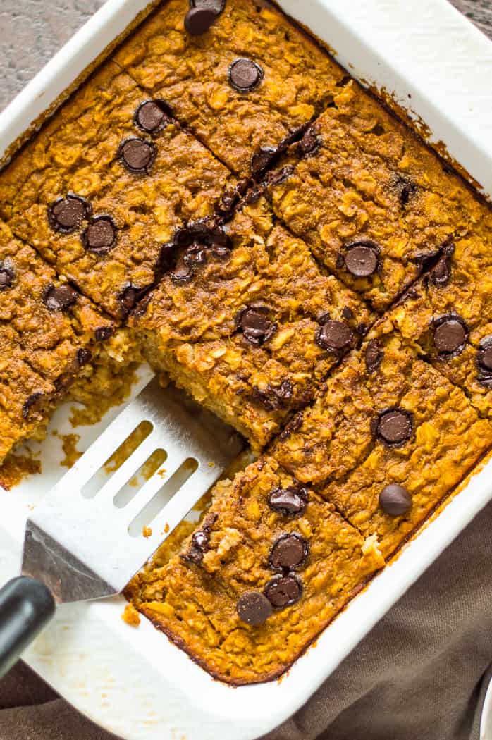 Baked pumpkin oatmeal in a tray with a slice missing. 