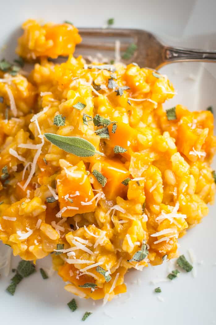 Instant Pot butternut squash risotto in a bowl with a fork topped with chopped sage.