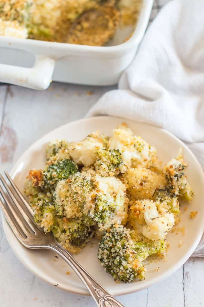 A serving of broccoli cauliflower casserole on a plate with a fork.