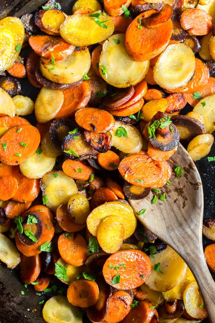 Easy 10-Minute Sautéed Carrots with a wooden spoon on top