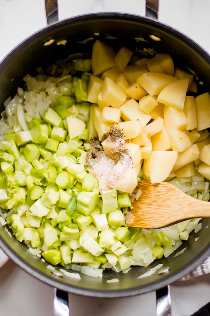 Broccoli, salt, pepper, and potatoes in a pot.