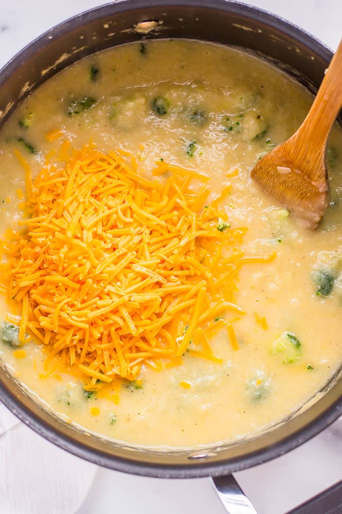 Grated cheddar cheese on top of broccoli cheddar soup before being stirred in.