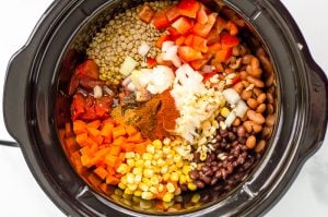 Ingredients for slow cooker vegetarian chilu in a slow cooker before cooking or being stirred together.