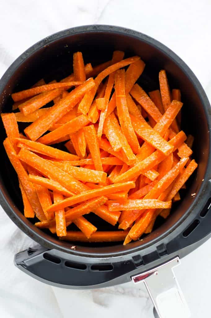 Carrot fries in an air fryer basket.