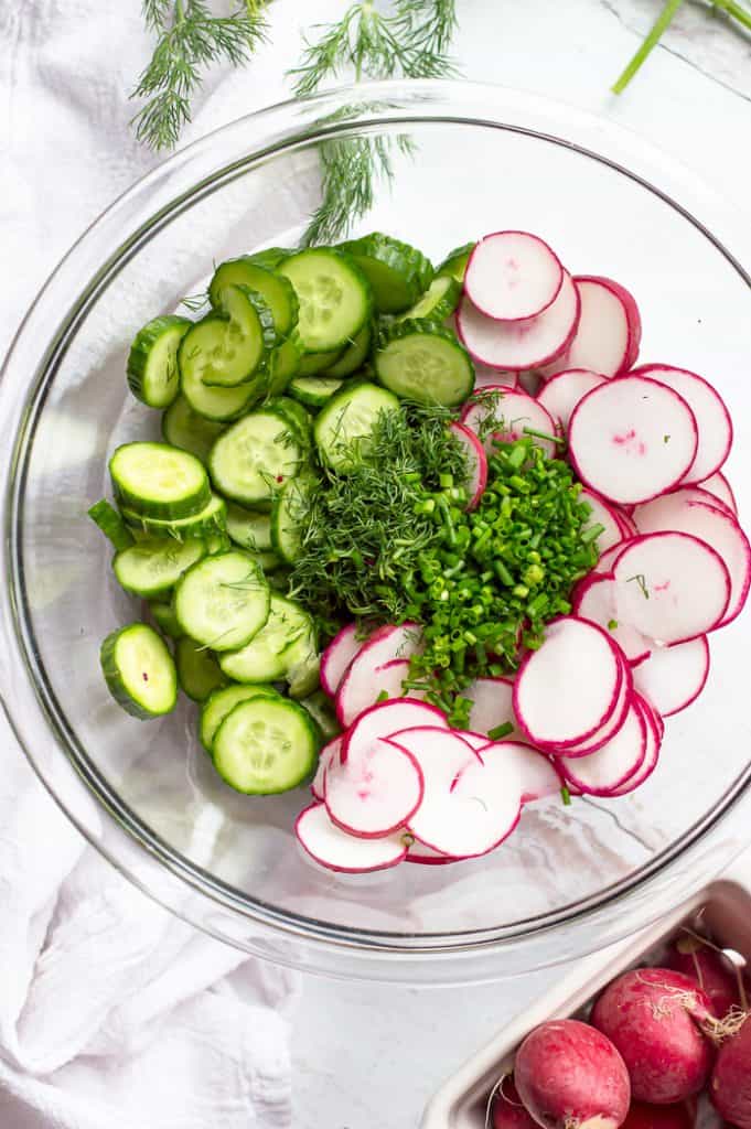 The ingredients for cucumber radish salad in a bowl before mixing.