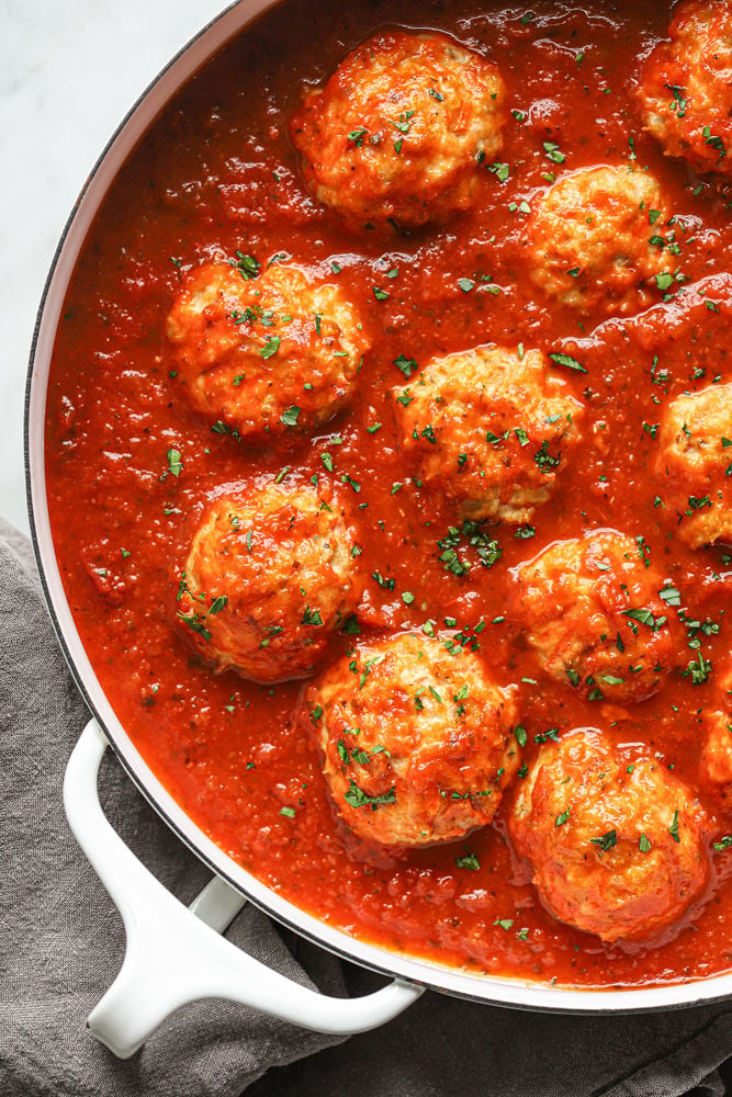 Chicken Carrot meatballs in a pot with sauce.