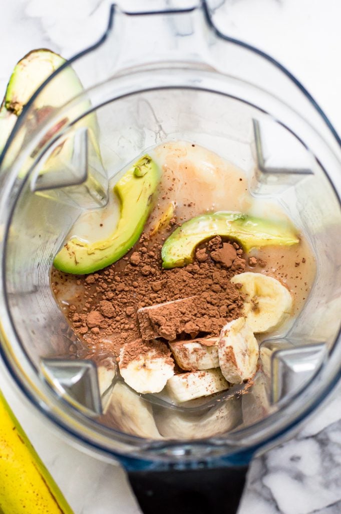 Ingredients for an avocado smoothie in a blender before mixing. 