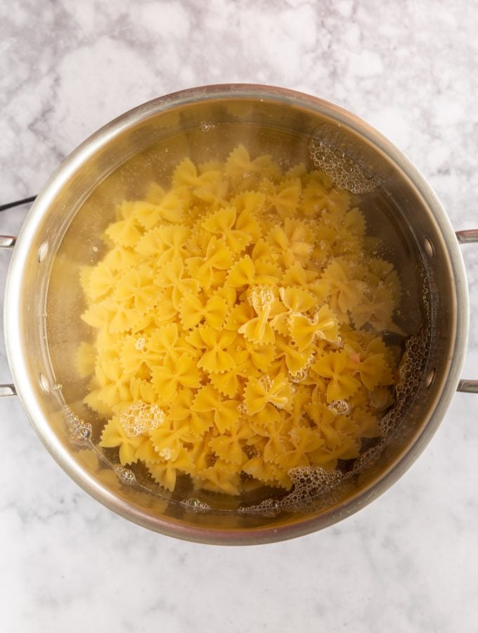 Bowtie pasta cooking in a pot of water.
