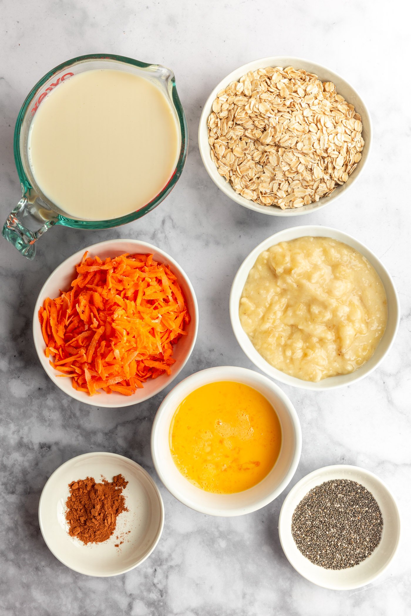 Ingredients for carrot banana protein oats on a table before being made into the recipe. 