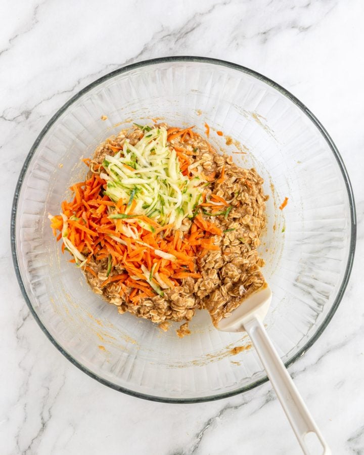 Grated carrots and zucchini in the bowl with the batter for veggie-loaded breakfast cookies before being stirred in.