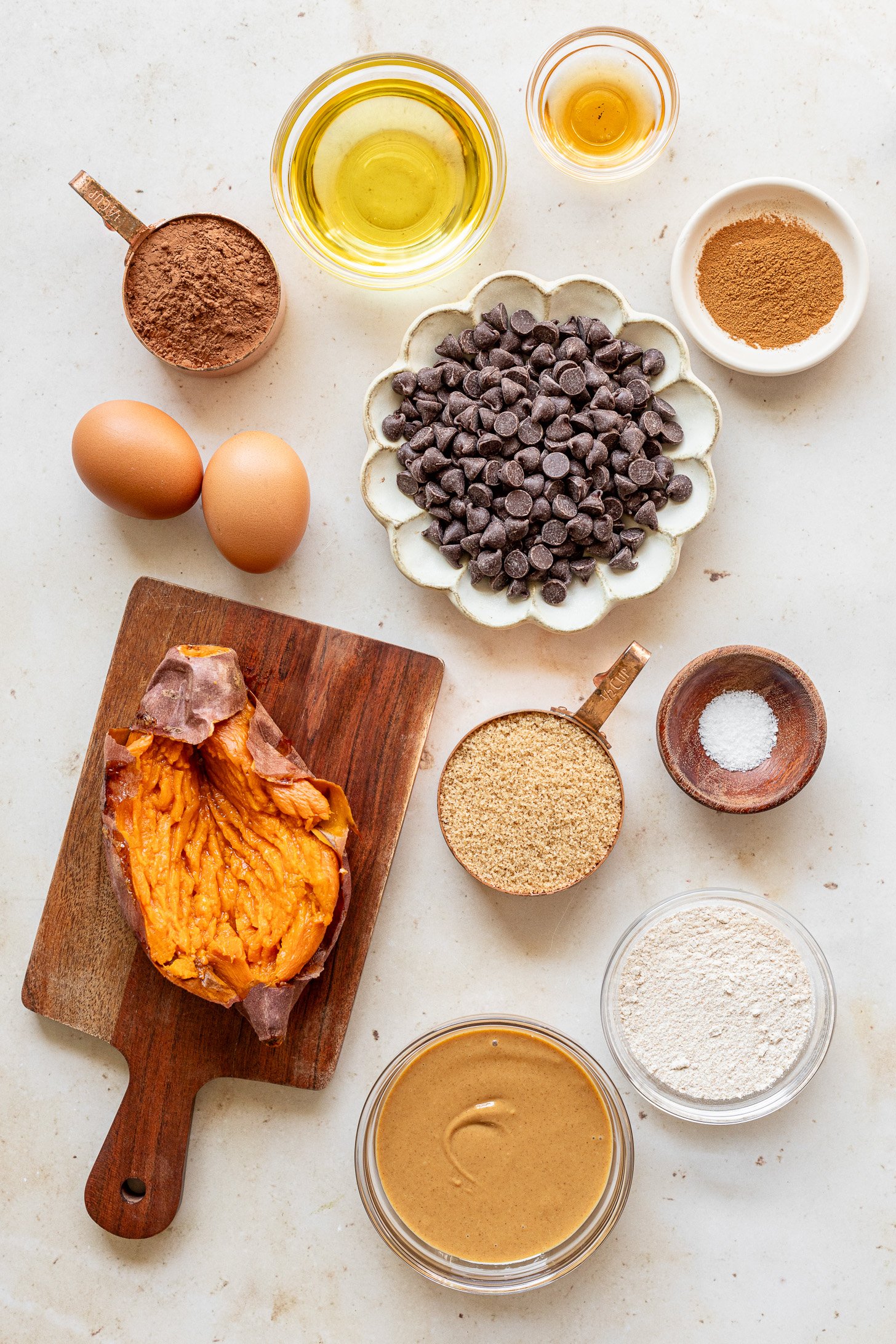 Ingredients for fudgy sweet potato brownies in bowls on a table before bing made into a batter.