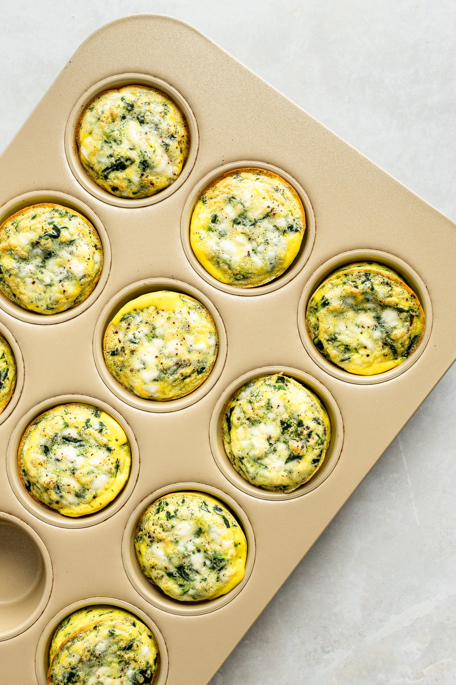 Spinach Feta egg cups in a muffin tin, fresh out of the oven.