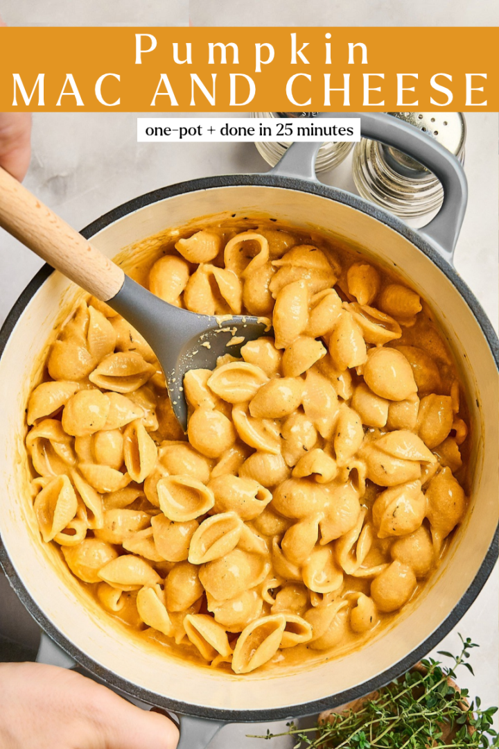 A silicone spoon stirs creamy pumpkin mac and cheese in a grey pot, with text overlay reading Pumpkin MAC AND CHEESE and one-pot + done in 25 minutes.